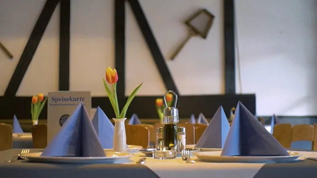 Gastraum mit Fachwerk, gedeckten Tischen und blauen Servietten